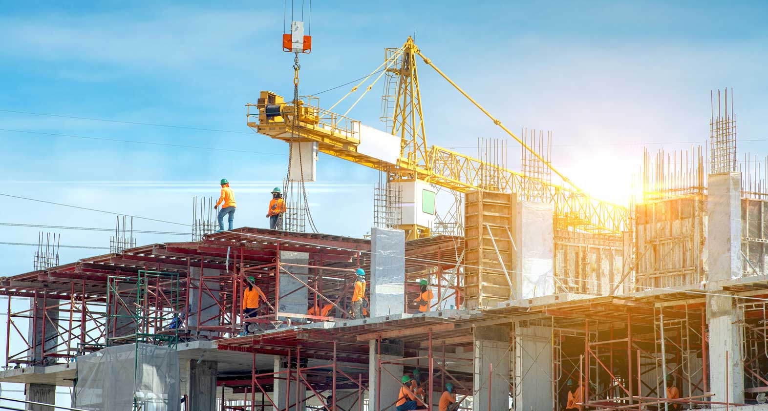 Shell construction of an office building with a crane and people in Benin