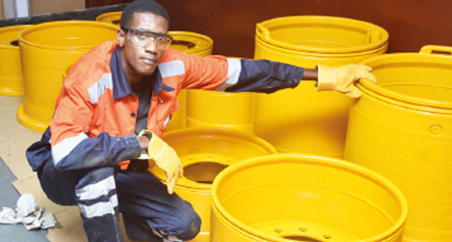 Un employé de Wendit avec des jantes larges jaunes restaurées pour camion