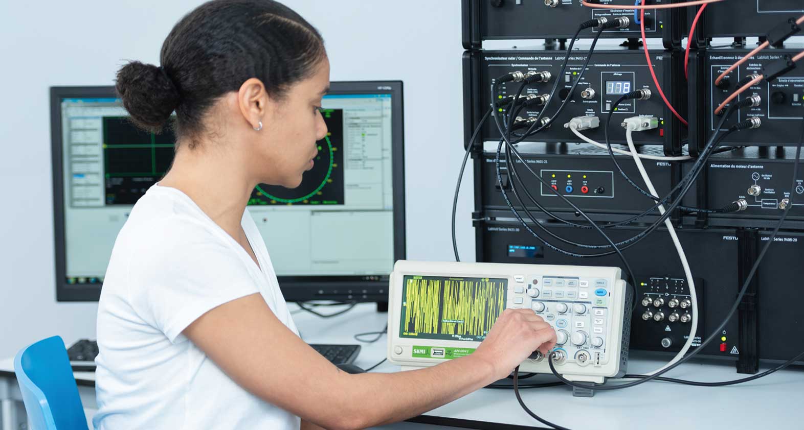 Personne suivant une formation sur un tableau de commande et un appareil de mesure dans un conteneur de formation Festo